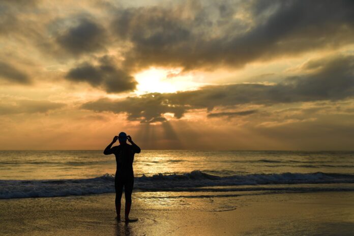 PORT ELIZABETH - AUGUST 30: General views of a triathlete entering the water warming up leading up to the Isuzu IRONMAN 70.3 World Championship at Hobie Beach in Port Elizabeth, South Africa on August 30, 2018. (Photo by Donald Miralle/Getty Images for IRONMAN).